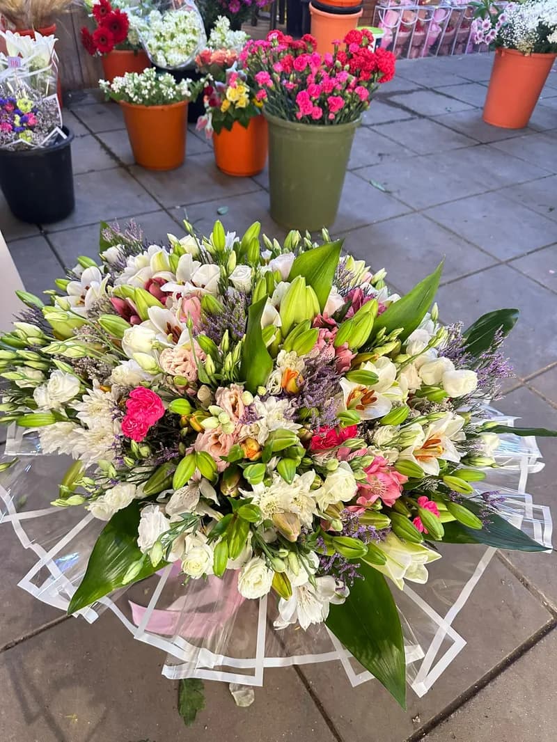 זר עגול גדול של שושנים ואלסטרומריה בצבעים לבן, ורוד וסגול — צילום מלמעלה
